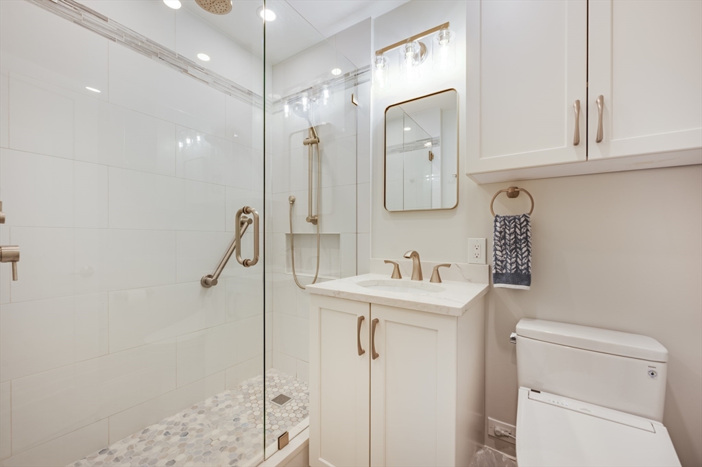 85 East India Row, Unit 34G Boston, MA 02110 - Photo 9 of 20 a bathroom with a sink a toilet and a mirror