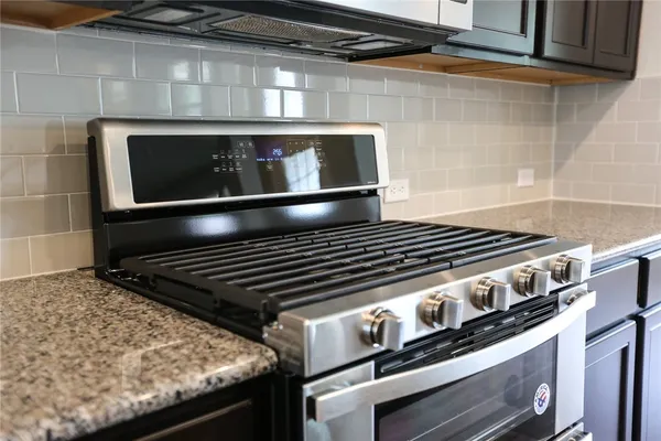 a stove top oven sitting inside of a kitchen