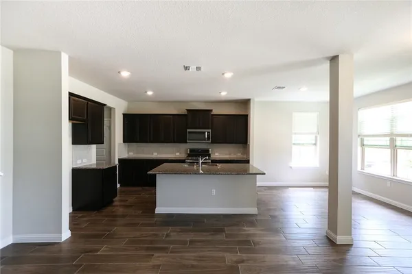 a view of kitchen with stainless steel appliances kitchen island sink stove and refrigerator