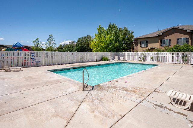 1177 Northfield Road, Unit 26 Cedar City, UT 84721 - Photo 43 of 45 In-ground swimming pool with a concrete deck, surrounded by a white picket fence