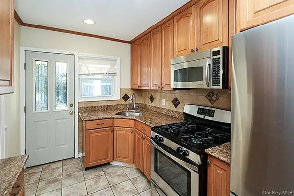 a kitchen with stainless steel appliances granite countertop a stove a sink and a refrigerator