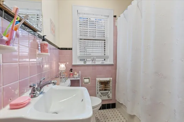 a bathroom with a sink a toilet and shower curtain