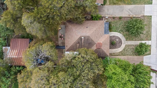 an aerial view of a house with a yard and large trees