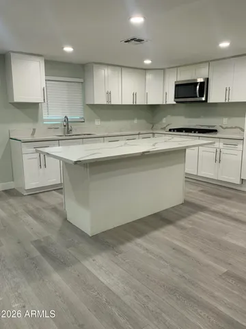 a kitchen with granite countertop a sink and cabinets