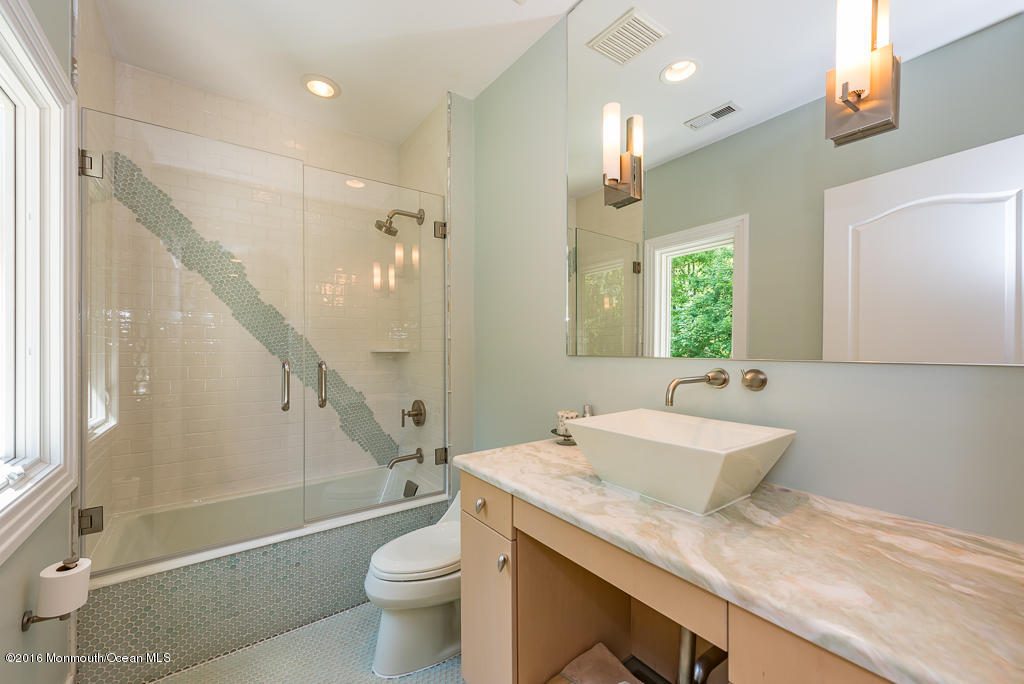 500 Farm Bridge Road Marlboro, NJ 07746 - Photo 33 of 57 a bathroom with a granite countertop sink a toilet a mirror and shower