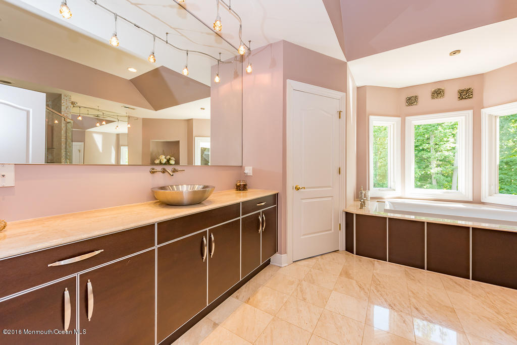 500 Farm Bridge Road Marlboro, NJ 07746 - Photo 45 of 57 a spacious bathroom with a double vanity sink a large mirror and a bathtub