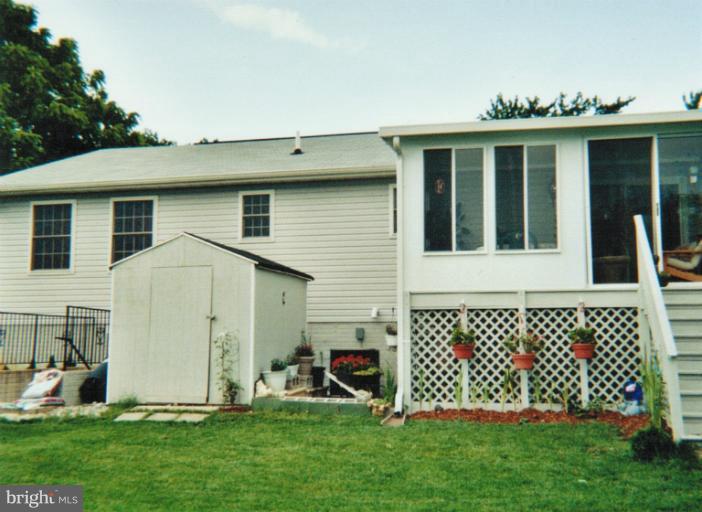 1213 Krueger Avenue Rosedale, MD 21237 - Photo 2 of 27 a view of a house with a large window and a yard with wooden fence