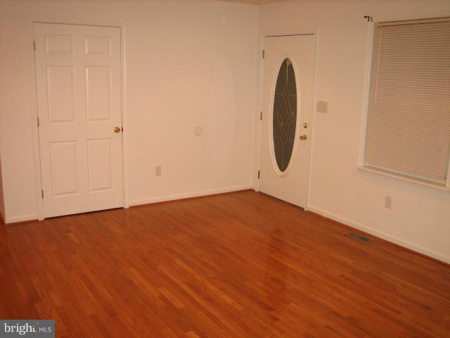 1213 Krueger Avenue Rosedale, MD 21237 - Photo 3 of 27 an empty room with wooden floor and windows