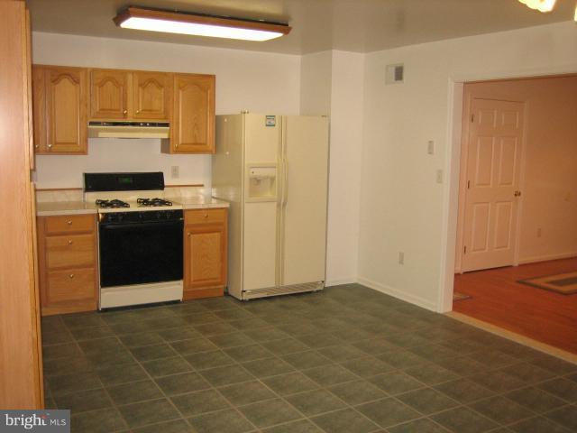1213 Krueger Avenue Rosedale, MD 21237 - Photo 4 of 27 a kitchen with stainless steel appliances granite countertop a stove a refrigerator and a cabinets