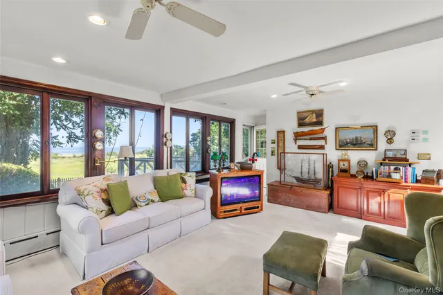 a living room with furniture a flat screen tv and a large window