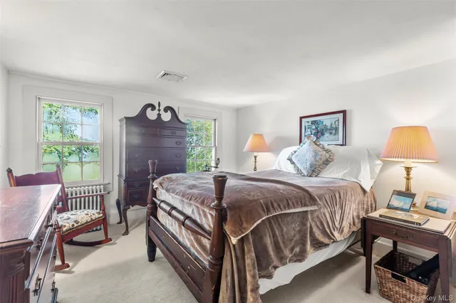 a bedroom with a bed table chair and a window