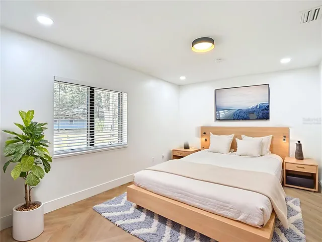 a bedroom with a bed and a potted plant