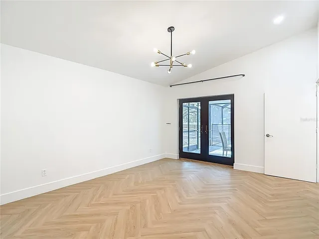 a view of an empty room with kitchen and kitchen view
