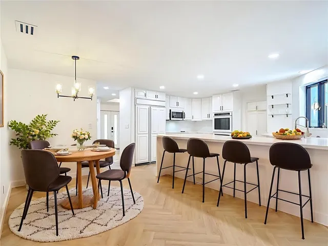 a view of a kitchen with stainless steel appliances refrigerator stove microwave and cabinets