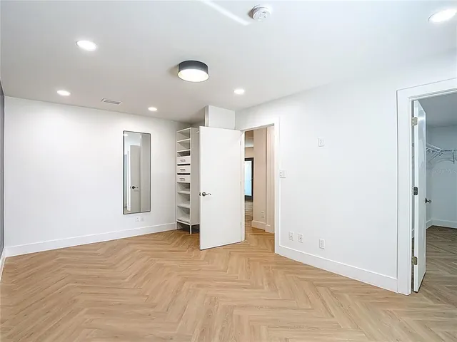 an empty room with a ceiling fan and window