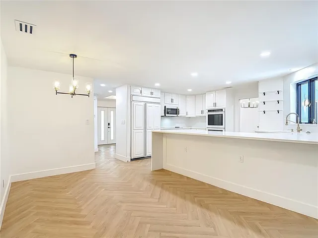 a kitchen with white cabinets and white appliances