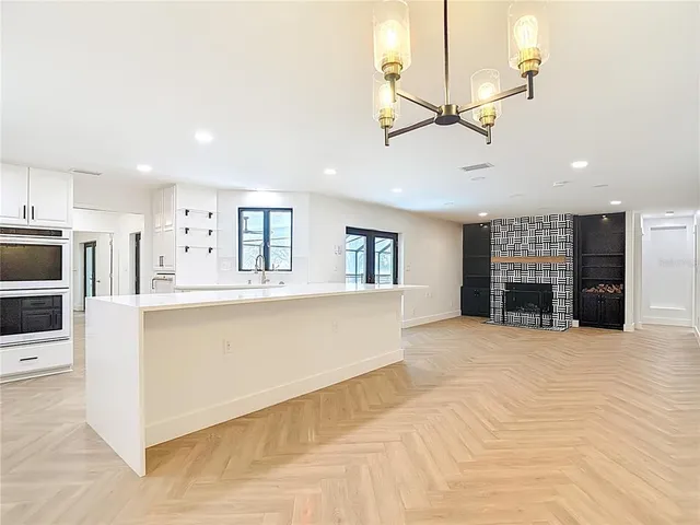 a kitchen with stainless steel appliances white cabinets a stove a sink and a microwave