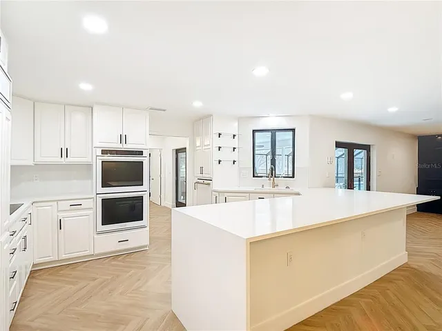 a kitchen with granite countertop white cabinets and white appliances