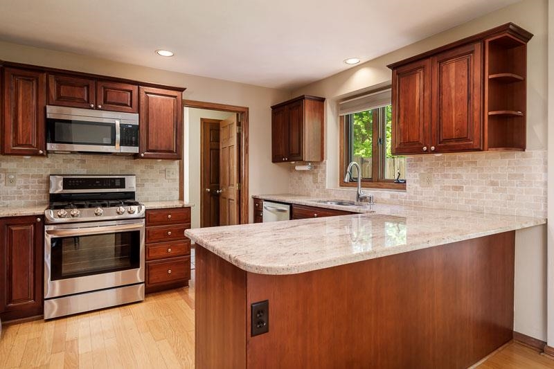 8833 West Ridge Drive Belvidere, IL 61008 - Photo 35 of 65 a kitchen with stainless steel appliances granite countertop a stove a sink and a microwave