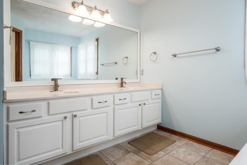 8833 West Ridge Drive Belvidere, IL 61008 - Photo 45 of 65 a spacious bathroom with a double vanity sink and a mirror