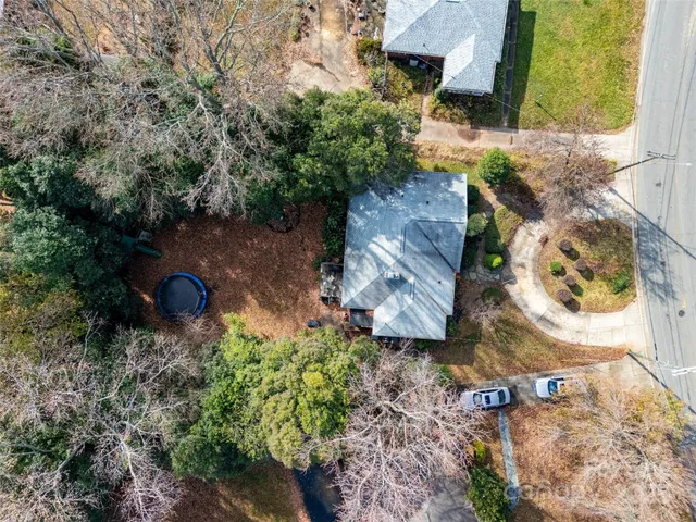an aerial view of a house with a yard and a large tree