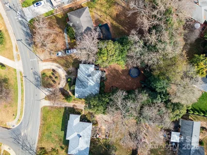 an aerial view of a house with a yard and greenery