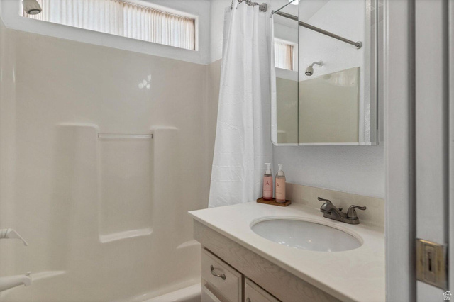 2990 East Riverside Drive, Unit 173 St. George, UT 84790 - Photo 10 of 38 Bathroom featuring an integrated shower/tub unit with a built-in shelf, a white vanity with an undermount sink, a chrome faucet, and a mirrored medicine cabinet