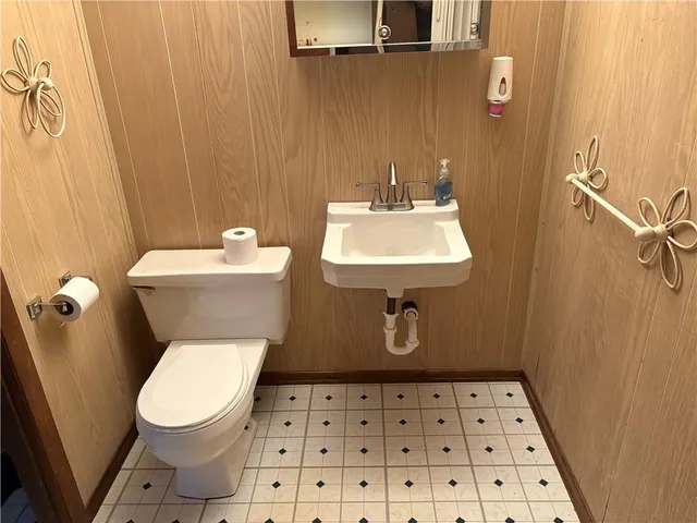 a bathroom with a sink a toilet and a mirror