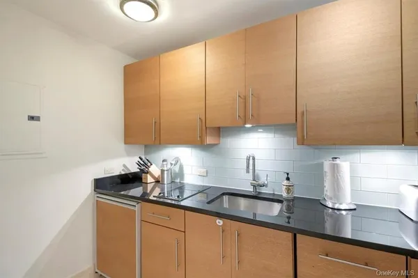 a kitchen with stainless steel appliances granite countertop a sink a refrigerator and cabinets