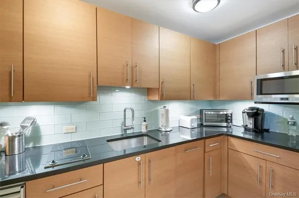 a kitchen with stainless steel appliances granite countertop a sink a stove and cabinets