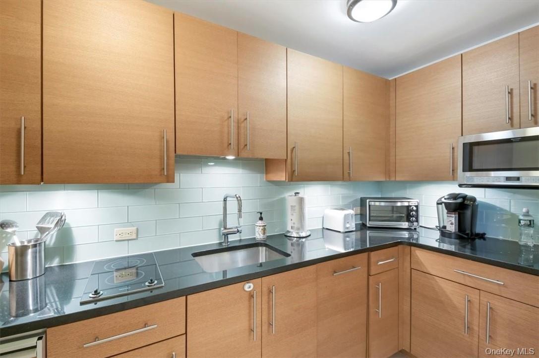 1 Renaissance Square, Unit 7B White Plains, NY 10601 - Photo 4 of 10 a kitchen with stainless steel appliances granite countertop a sink a stove and cabinets