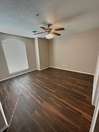 a view of an empty room with window and wooden floor