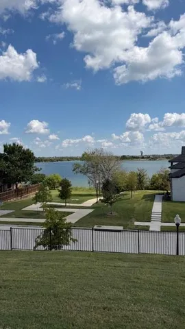 a view of lake with green yard
