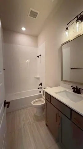 a bathroom with a granite countertop sink toilet and a mirror