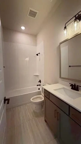 a bathroom with a granite countertop sink toilet and a mirror