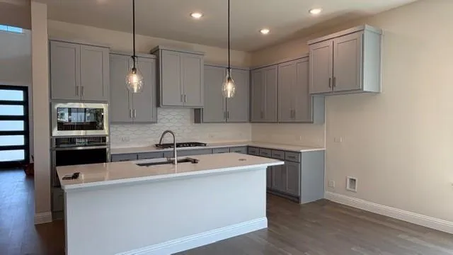 a kitchen with stainless steel appliances granite countertop a sink a stove and a refrigerator