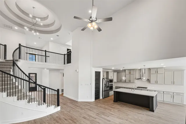 a view of a room with wooden floor and ceiling fan