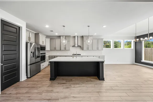 a large kitchen with kitchen island a sink stainless steel appliances and cabinets