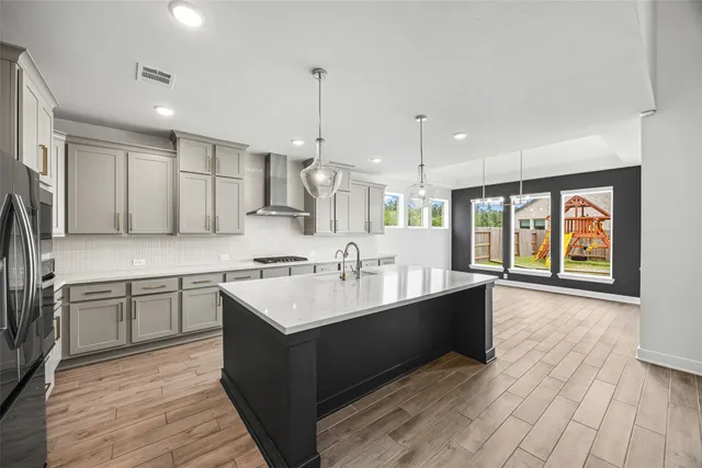 a large white kitchen with a large window a sink and stainless steel appliances