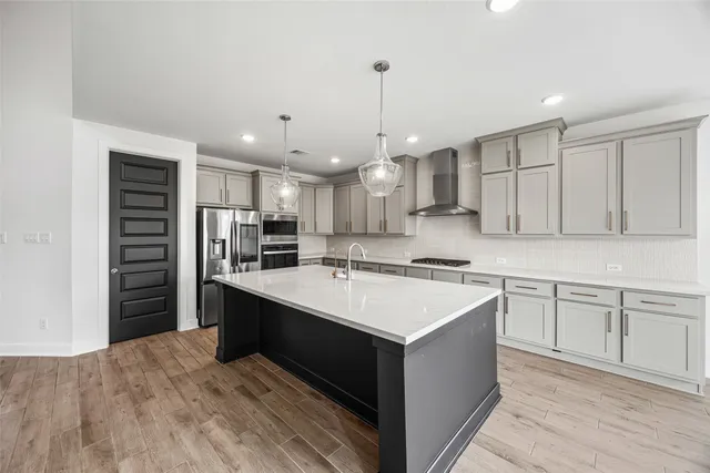 a kitchen with kitchen island a sink stainless steel appliances and white cabinets