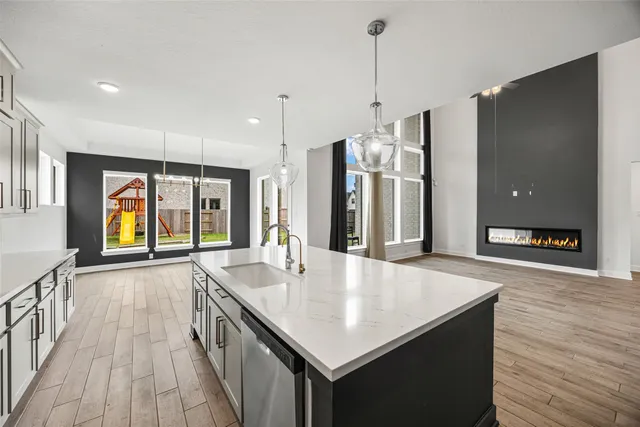 a kitchen with stainless steel appliances granite countertop a sink a oven and a refrigerator with wooden floor