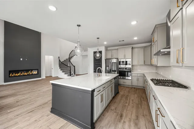 a large kitchen with stainless steel appliances kitchen island a large counter top and a stove