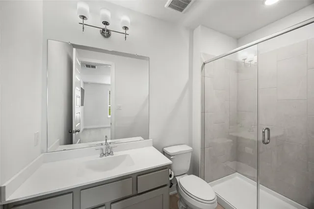 a bathroom with a sink toilet vanity and shower