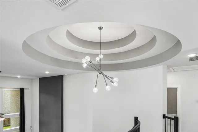 a room with a chandelier fan and a ceiling fan
