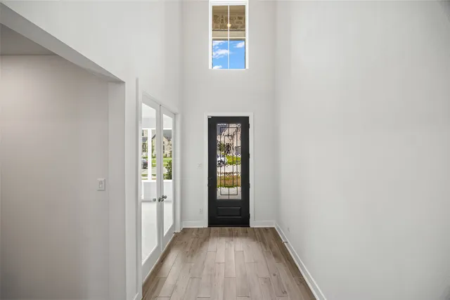 a view of a hallway with wooden floor and windows