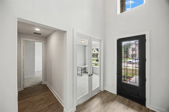 a view of a hallway with wooden floor and closet