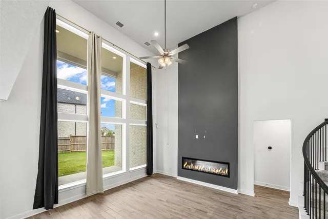 a view of an empty room with a window and a ceiling fan