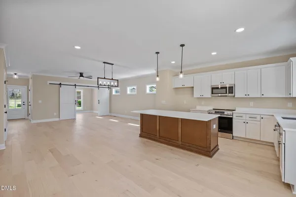 a living room with furniture kitchen and a large window