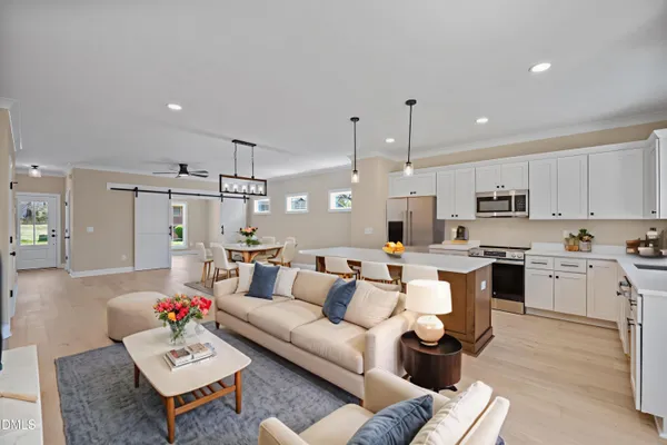 a large kitchen with stainless steel appliances granite countertop a stove a sink dishwasher and a refrigerator with white cabinets