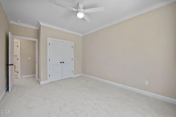 an empty room with windows and ceiling fan